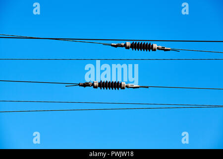 Overhead train electric traction system against the blue sky. Stock Photo