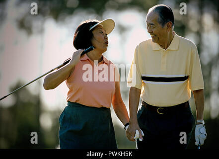 Mature couple having fun while playing golf together. Stock Photo