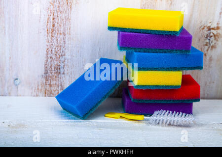 Multi-colored sponges for washing dishes on a wooden background. Stock Photo