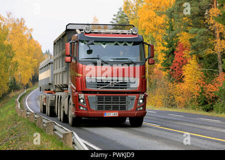 Salo, Finland - October 13, 2018: Red Volvo FH 16 750 truck up front in seasonal sugar beet haul on rural highway flanked by autumn foliage. Stock Photo