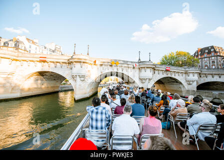 PARIS, FRANCE - August 31, 2018: Tourists enjoy water tour on Seine river sailing on the two stored open boat in Paris Stock Photo