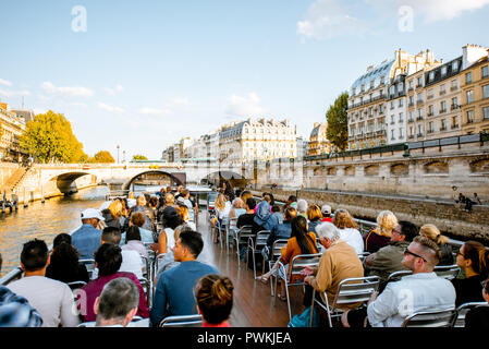 PARIS, FRANCE - August 31, 2018: Tourists enjoy water tour on Seine river sailing on the two stored open boat in Paris Stock Photo