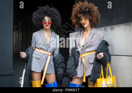 LONDON, UK- SEPTEMBER 14 2018: People on the street during the London Fashion Week. Two girls with combed hair in gray checkered suits and blue and ye Stock Photo
