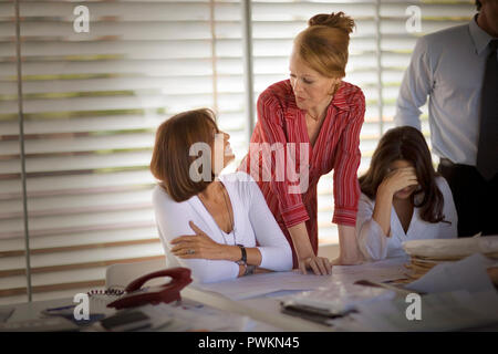 Group of business colleagues having a discussion around a table inside a boardroom. Stock Photo