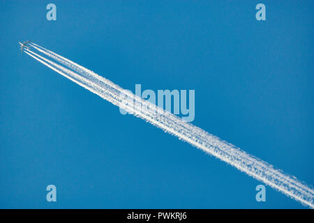 A long trail of jet plane on blue sky background. Stock Photo