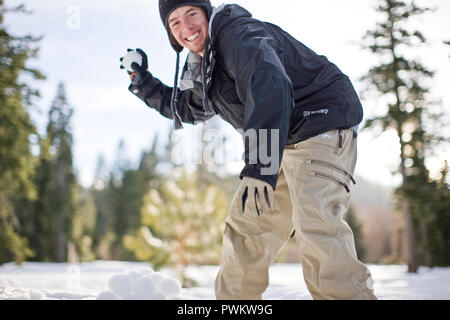 Young man preparing to throw a snowball Stock Photo