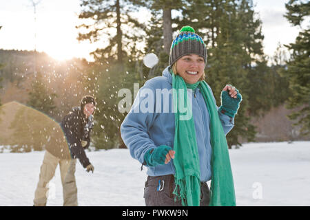 Man throwing a snowball at a woman Stock Photo