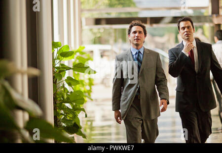 Portrait of two businessmen walking through an office building lobby. Stock Photo