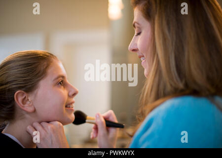 Mother putting make-up on daughter Stock Photo