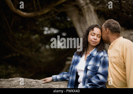 Mature couple leaning against a tree Stock Photo