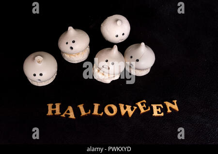 Little candy ghosts with the word Halloween isolated on black background Stock Photo