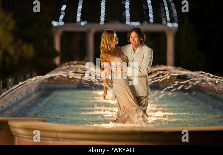 Happy mid adult couple dancing in a fountain. Stock Photo