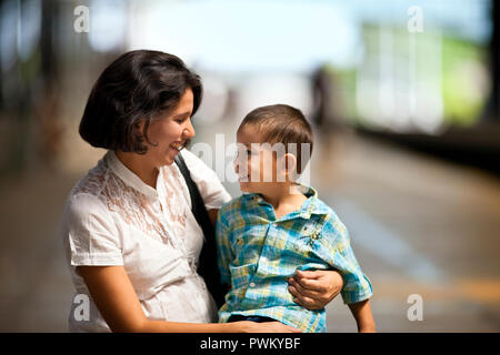 Thirtysomething mother and her son at a railway station. Stock Photo