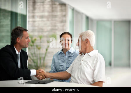 Senior couple having a meeting on their patio with a businessman. Stock Photo