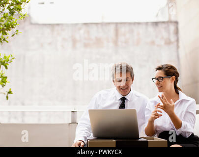 Businessman and woman working on a laptop. Stock Photo