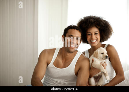Portrait of a couple holding a puppy. Stock Photo