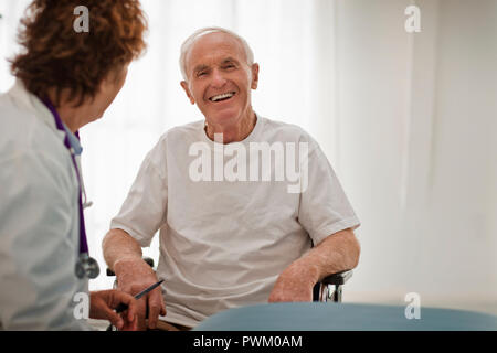 Portrait of a happy elderly man consulting with his doctor. Stock Photo