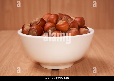 Nuts in a bowl on a wooden background, Brown nuts. Nuts.Side view. Stock Photo