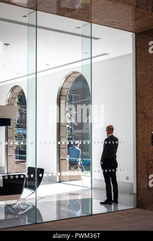 England,London, The City of London- corporate employee talking on his mobile phone in contemporary office Stock Photo