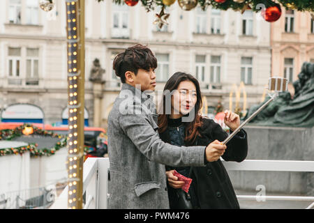 Prague, December 25, 2017: Young Asian couple taking selfie in memory of Prague in the Czech Republic during the Christmas holidays. Stock Photo