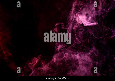 Textural background for creativity . Dense multicolored smoke of   red and pink colors on a black isolated background. Background of smoke vape Stock Photo