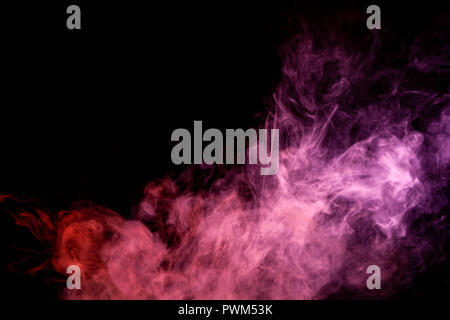 Textural background for creativity . Dense multicolored smoke of   red and pink colors on a black isolated background. Background of smoke vape Stock Photo