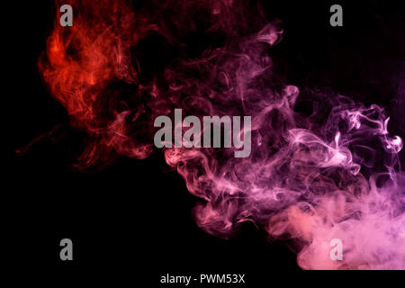 Textural background for creativity . Dense multicolored smoke of   red and pink colors on a black isolated background. Background of smoke vape Stock Photo