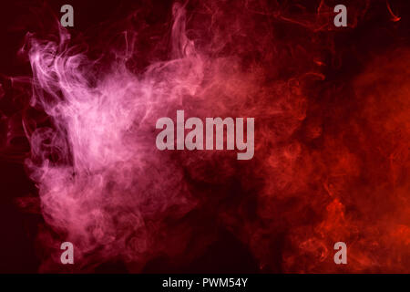 Textural background for creativity. Cloud of red and pink smoke on a black isolated background. Background from the smoke of vape Stock Photo