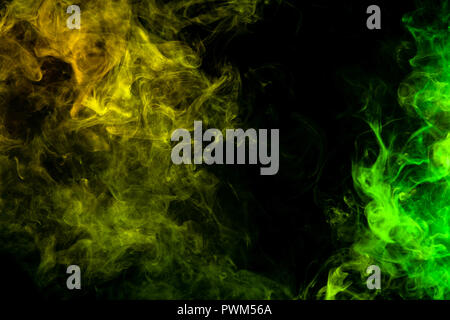 Textural background for creativity . Dense multicolored smoke of   green and yellow colors on a black isolated background. Background of smoke vape Stock Photo