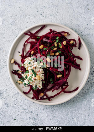 Raw beetroot spaghetti salad with soft cheese,nuts,thyme.Vegetable noodles - Fresh Beetroot Noodles with Ricotta and fresh thyme on plate. Copy space.Clean eating, raw vegetarian food concept.Top view Stock Photo