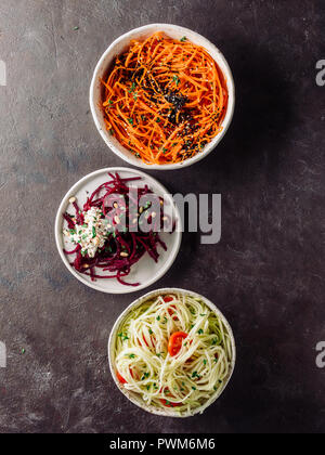Ideas and recipes for healthy salad - spicy sesame carrot noodles salad,raw beetroot noodles wih ricotta,zucchini zoodles salad with tomatoes.Various vegetarian salads ready-to-eat.Top view.Copy space Stock Photo