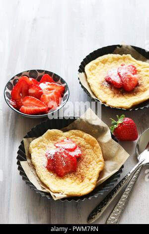 Cloud bread with cinnamon and fresh strawberries in tartlet tins Stock Photo