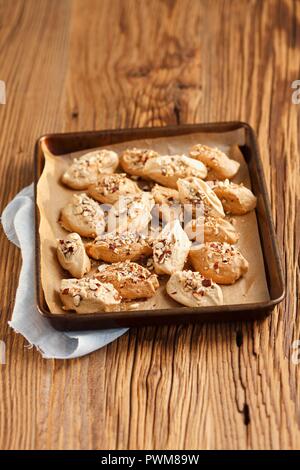 Meringues with cinnamon and nuts on a baking tray Stock Photo