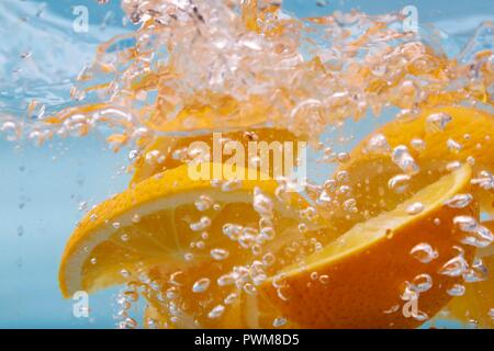 Orange slices in sparkling water Stock Photo
