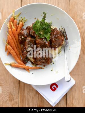 Oxtail ragout on mashed potatoes and parsnips with carrots Stock Photo