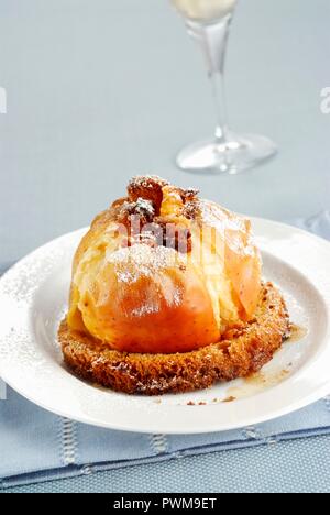 A baked apple served on a slice of panettone Stock Photo