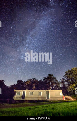 The milky way galaxy is seen above a caravan on a campsite near Aberystwyth in Wales, UK Stock Photo