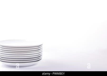 Stacked white plates on white background Stock Photo