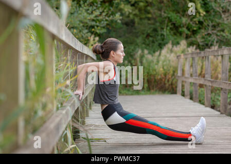 sporty woman stretching and exercising outside