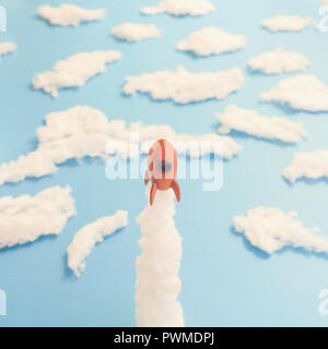 A rocket launch to space with a blue paper background and some cotton for the clouds. Stock Photo