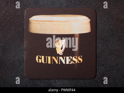 LONDON, UK - AUGUST 22, 2018: Guinness paper beer beermat coaster isolated on black background. Stock Photo