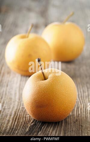 Three Nashi pears on a wooden surface Stock Photo