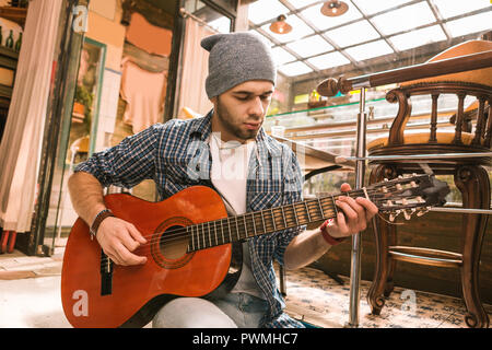 Pensive male guitarist practicing song in bar Stock Photo