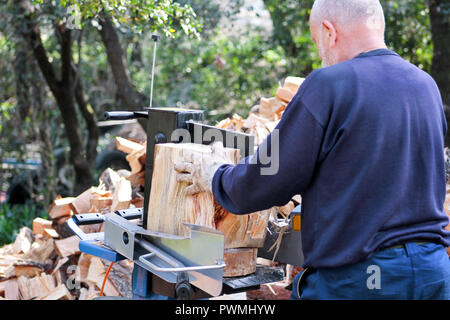 Saw cutting wood for winter. A man cutting firewood for the winter using a modern machine lumber saw. Wood industry. Heating season, winter season. Stock Photo