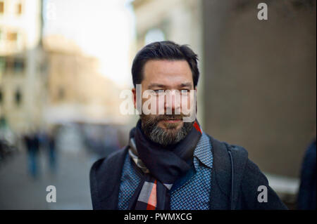 Portrait of a handsome bearded young man on a city street. Stock Photo