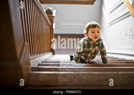 Toddler climbing up the stairs. Stock Photo