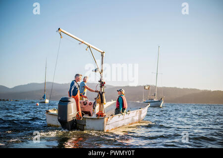 Family operating their fishing boat. Stock Photo