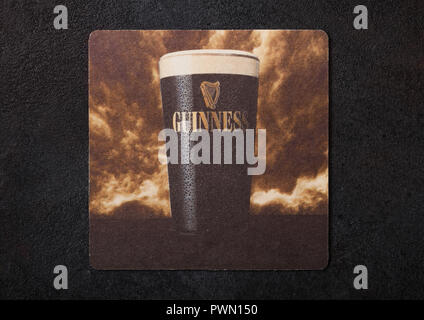 LONDON, UK - AUGUST 22, 2018: Guinness paper beer beermat coaster isolated on black background. Stock Photo