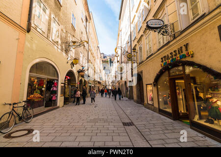 Salzburg, Austria - April 6, 2018: People strolling through Getreidegasse - famous shopping street in Salzburg old town. Stock Photo