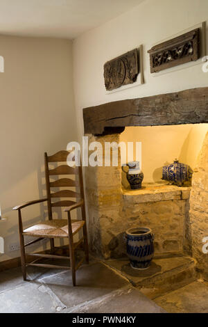 UK, England, Oxfordshire, Kelmscott Manor, the Old Kitchen Arts and Crafts Sussex chair beside fireplace Stock Photo